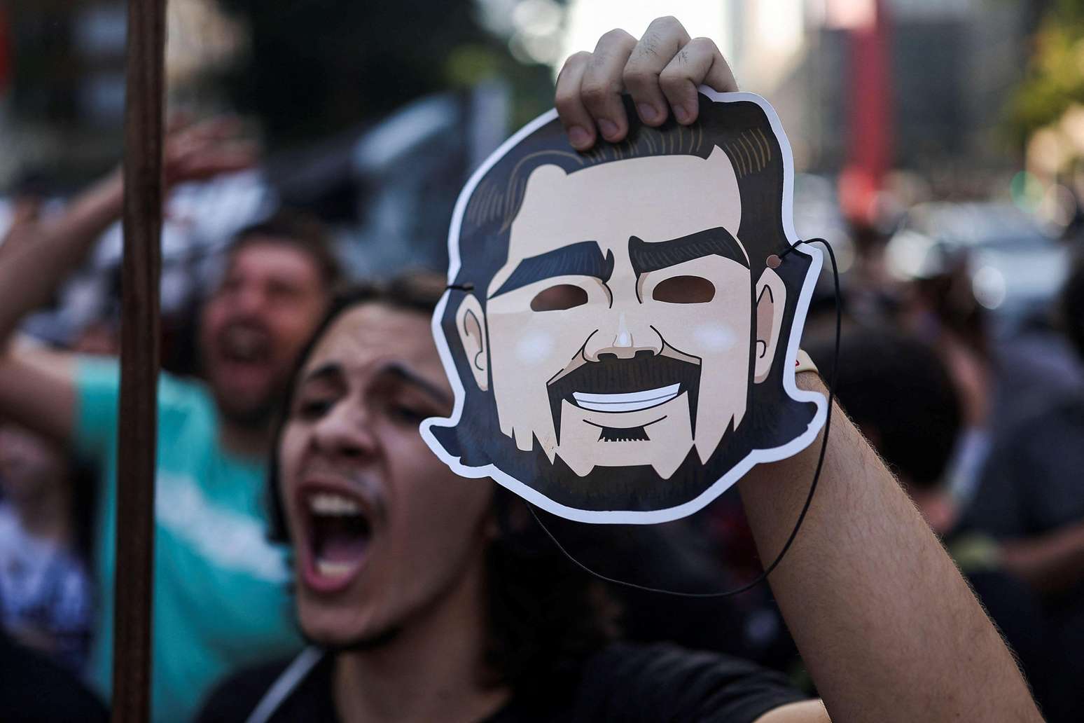 Manifestante segura mascara de Vorcaro
