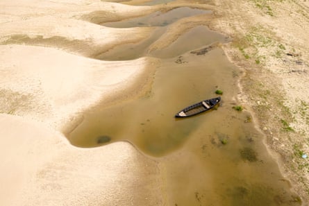 The Danube riverbed is exposed and a boat floats on a small area still containing water in Romania.