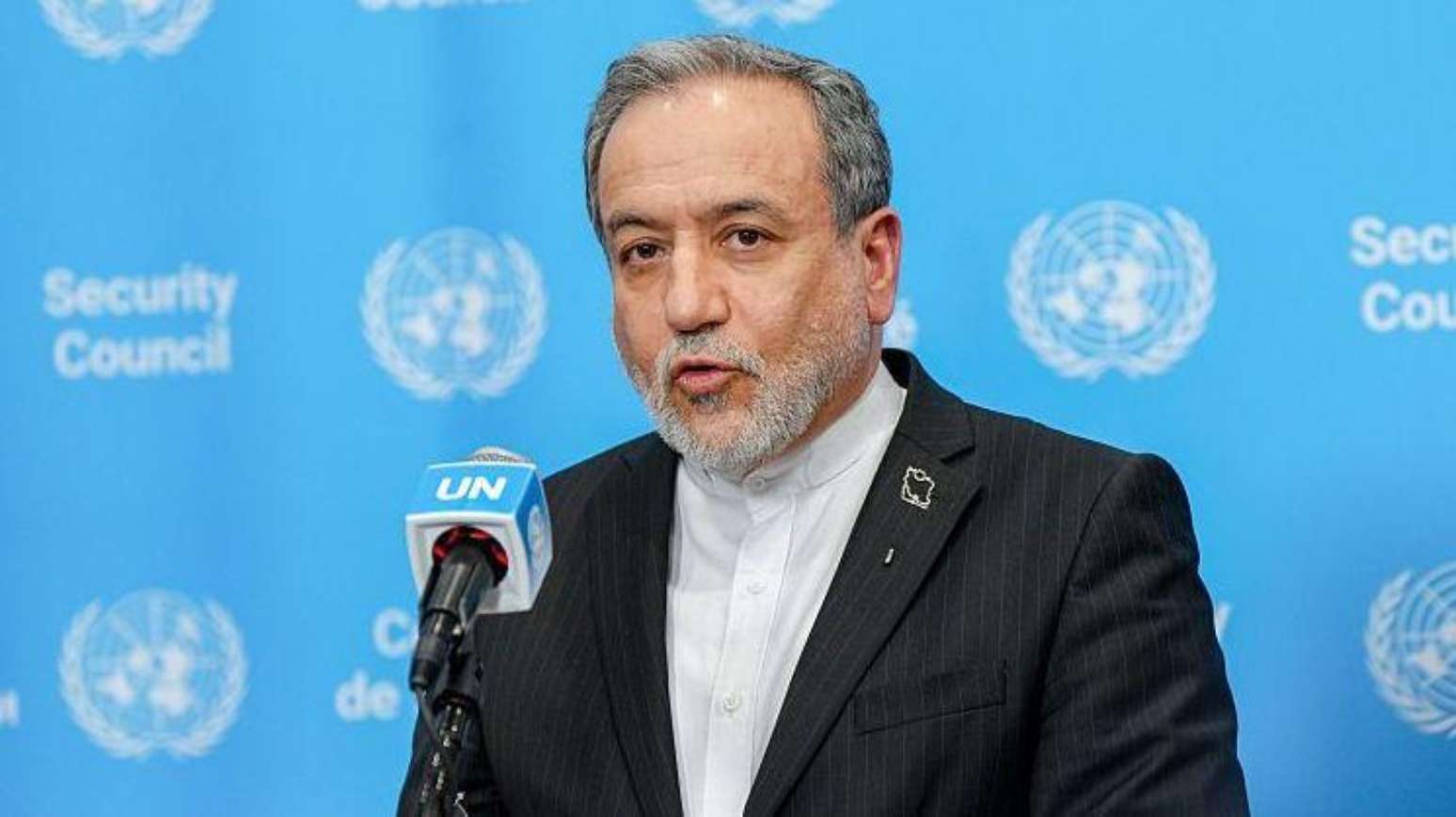 O ministro das Relações Exteriores do Irã, Abbas Araghchi, discursa em frente a um pódio tendo como fundo o azul da ONU.