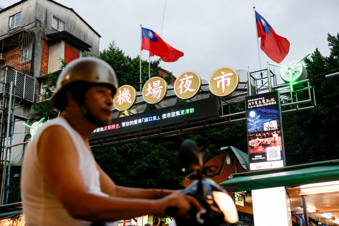 A person rides a scooter past Taiwan flags, above the entrance to Nanjichang Night Market, in Taipei, Taiwan, September 24, 2026. REUTERS/Ann Wang